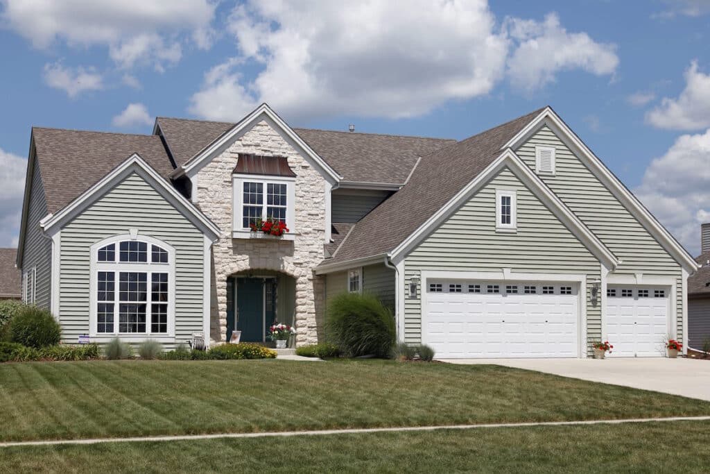 Home with stone entry and green vinyl siding