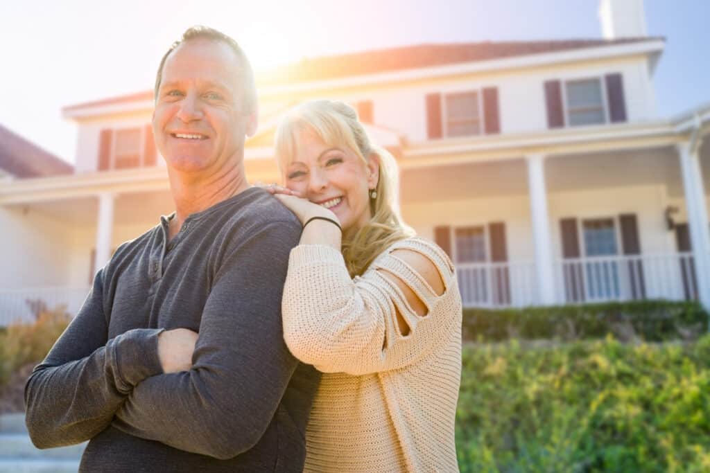 siding contractor couple in front of house